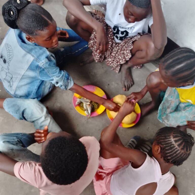 Enfants du centre One Love partageant un repas ensemble à Kinshasa